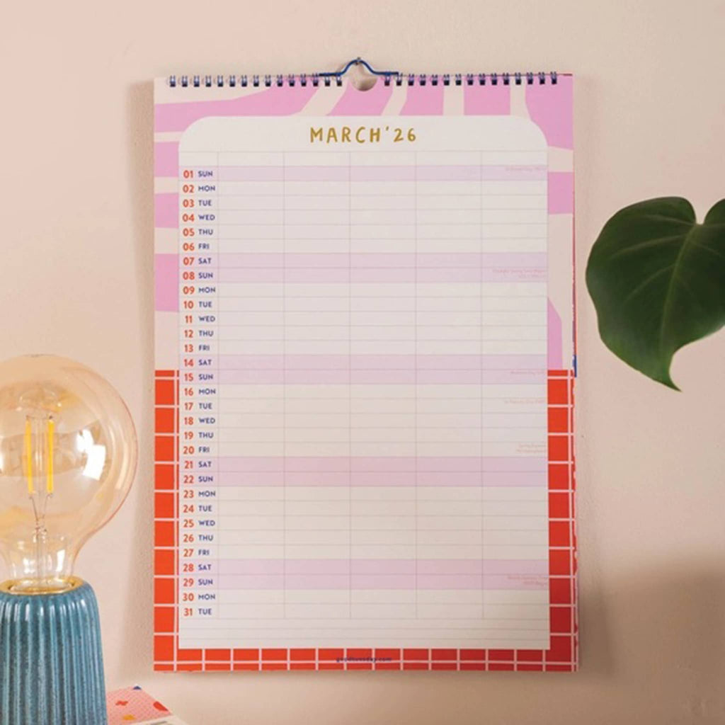 March 2026 month wall calendar with colorful design on a light pink wall.