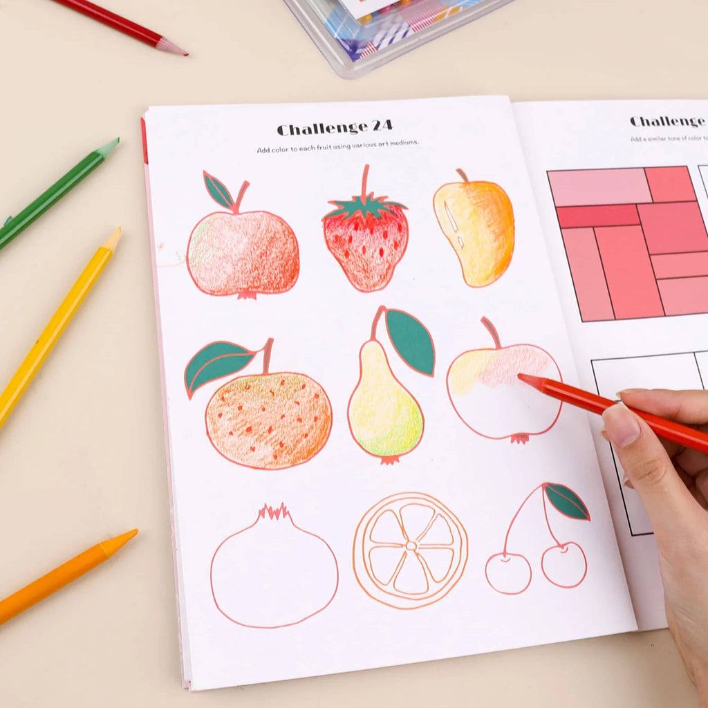 Coloring book with fruit illustrations and colored pencils on a beige surface.