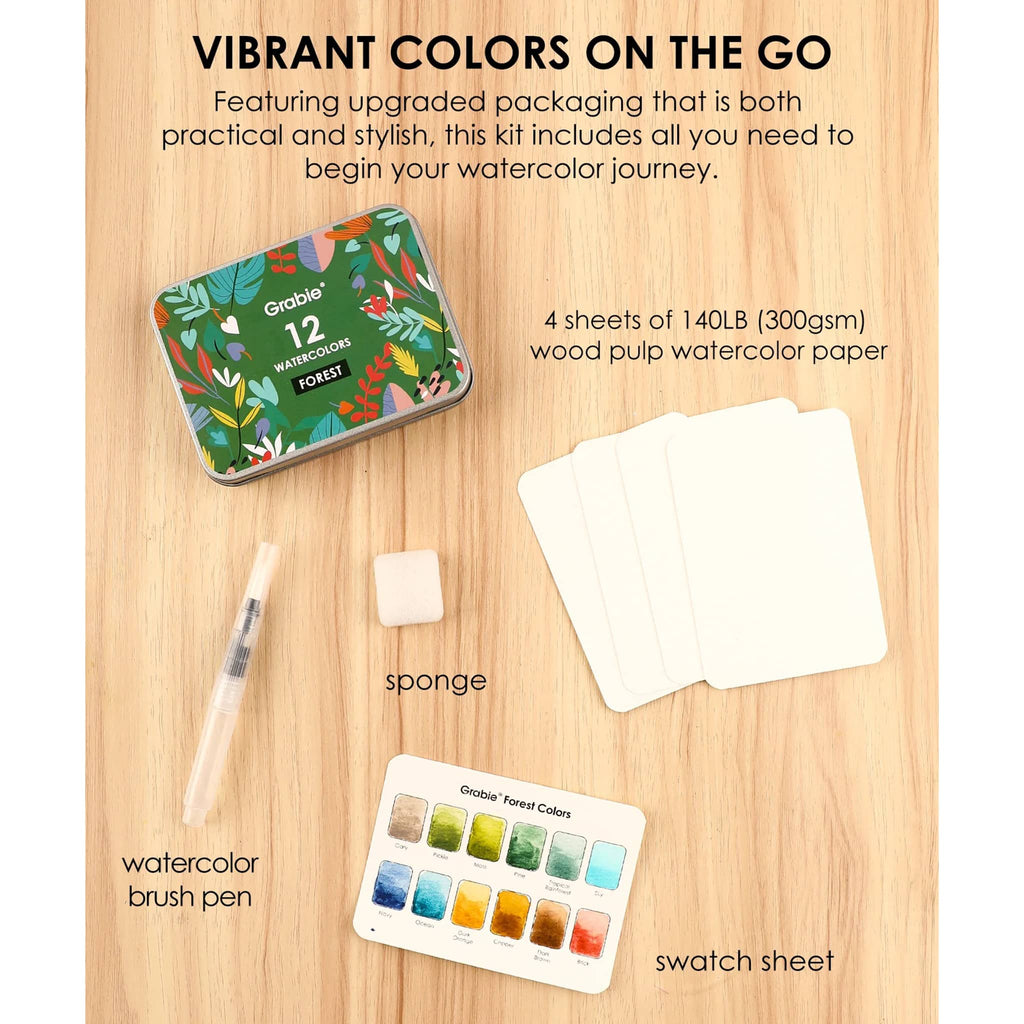 Watercolor kit with tin, paper, brush pen, sponge, and swatch sheet on a wooden surface.