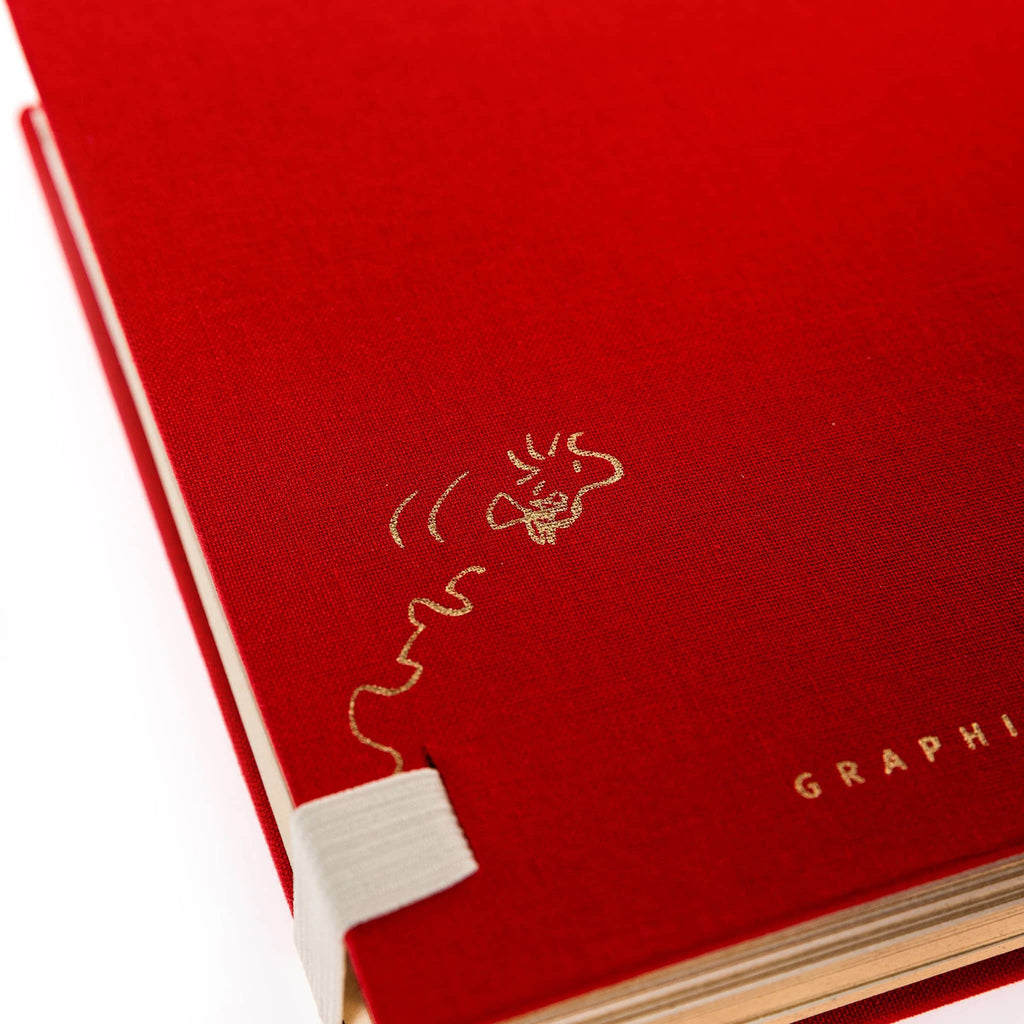 Back of a red notebook with an illustration of Woodstock flying in gold foil, on a white background.