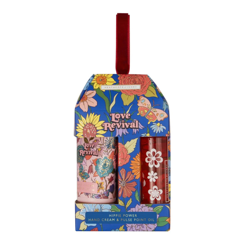 Heathcote & Ivory Love Revival Hippie Flower Calming Hand Cream and Pulse Point Oil gift set in 70s inspired floral paper packaging with red velvet ribbon hanger.
