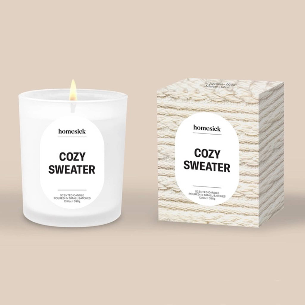 Homesick Cozy Sweater candle and packaging on a beige background.