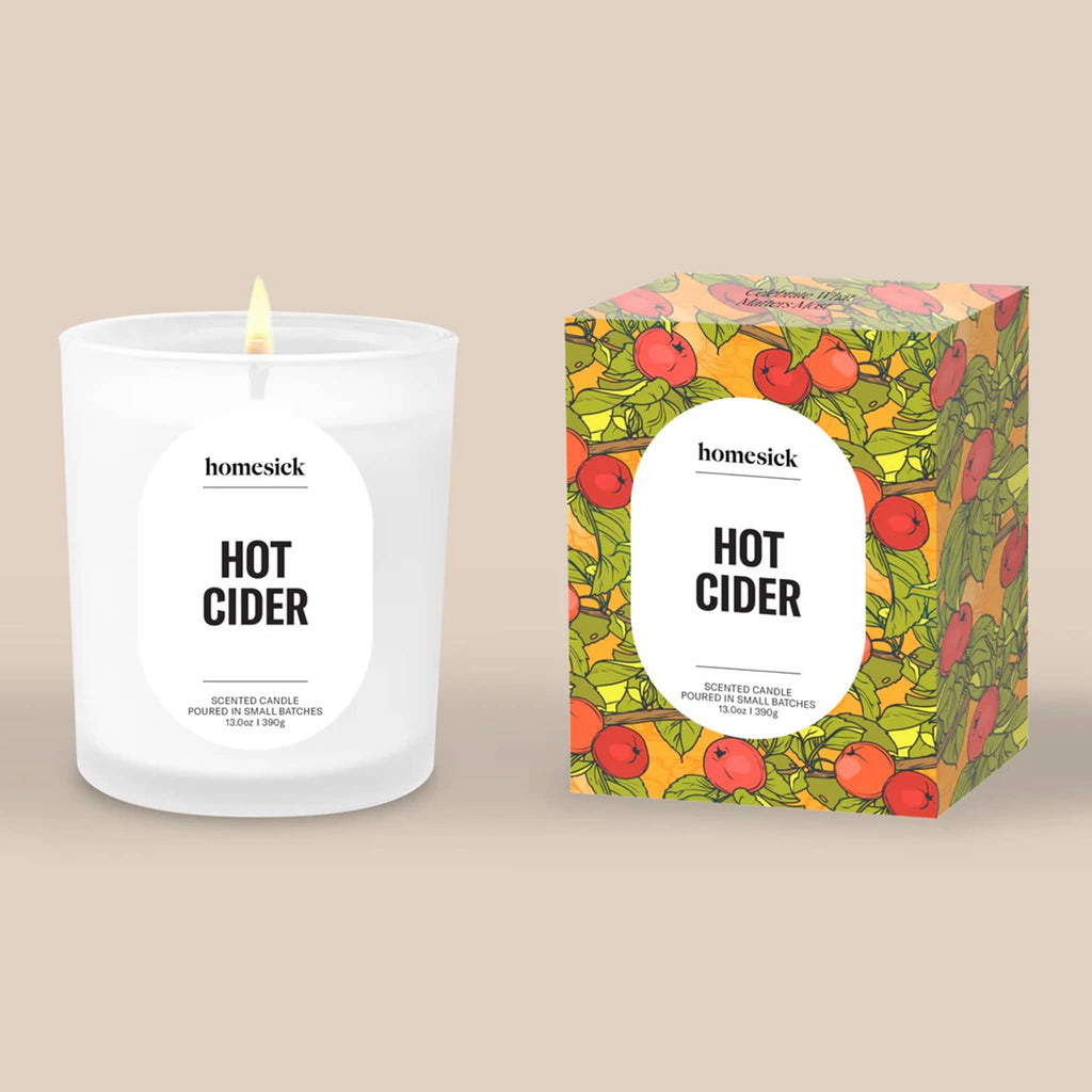 Homesick Hot Cider candle and packaging on a beige background.