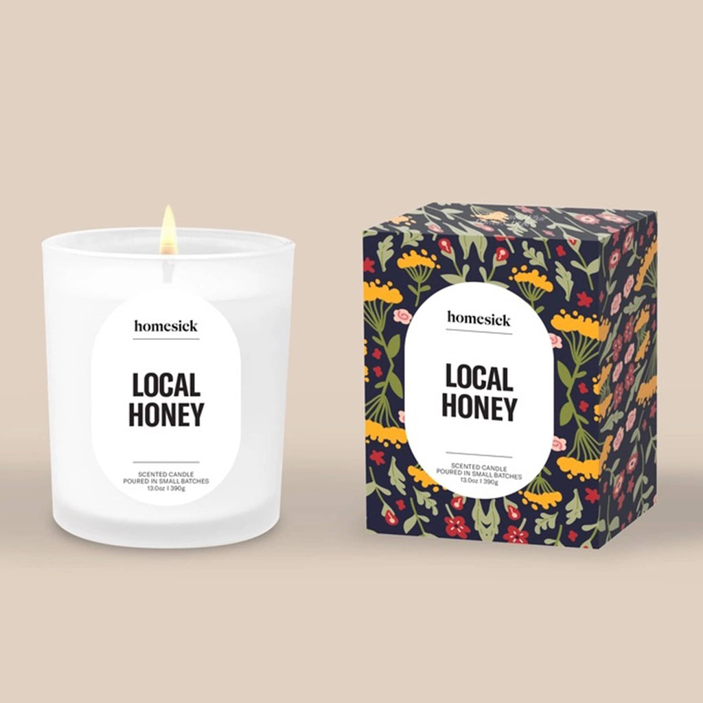 Homesick 'Local Honey' candle and packaging on a beige background.