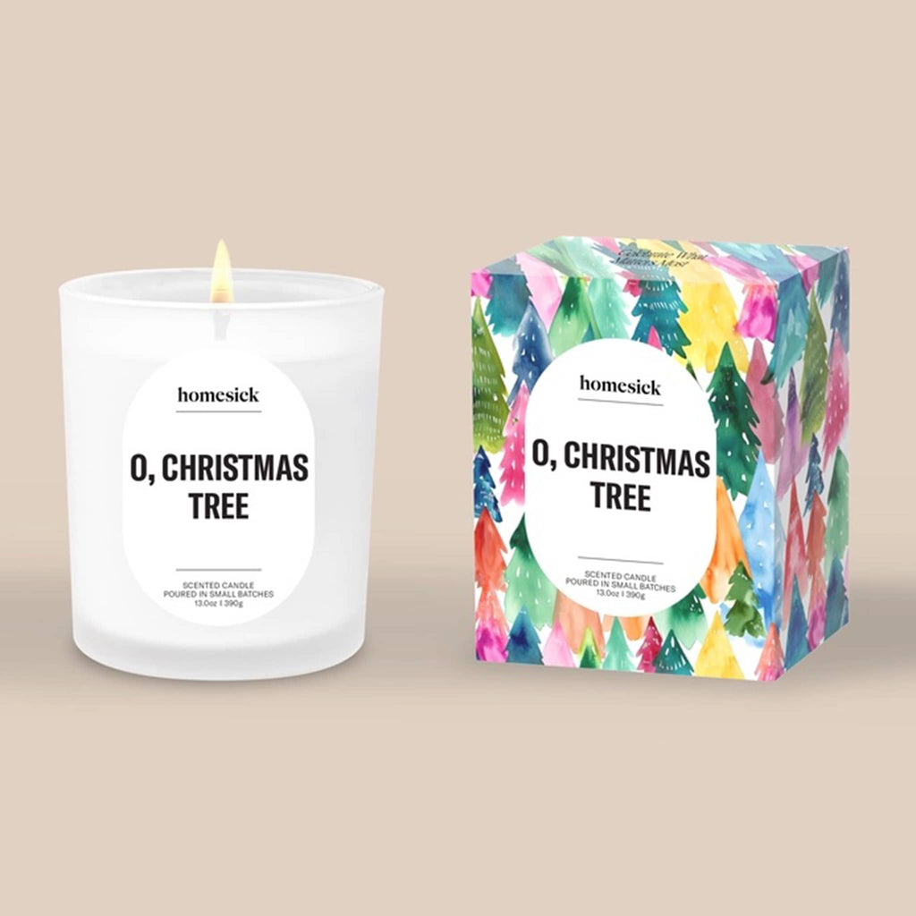 Homesick 'O, Christmas Tree' candle and colorful illustrated box on a beige background.