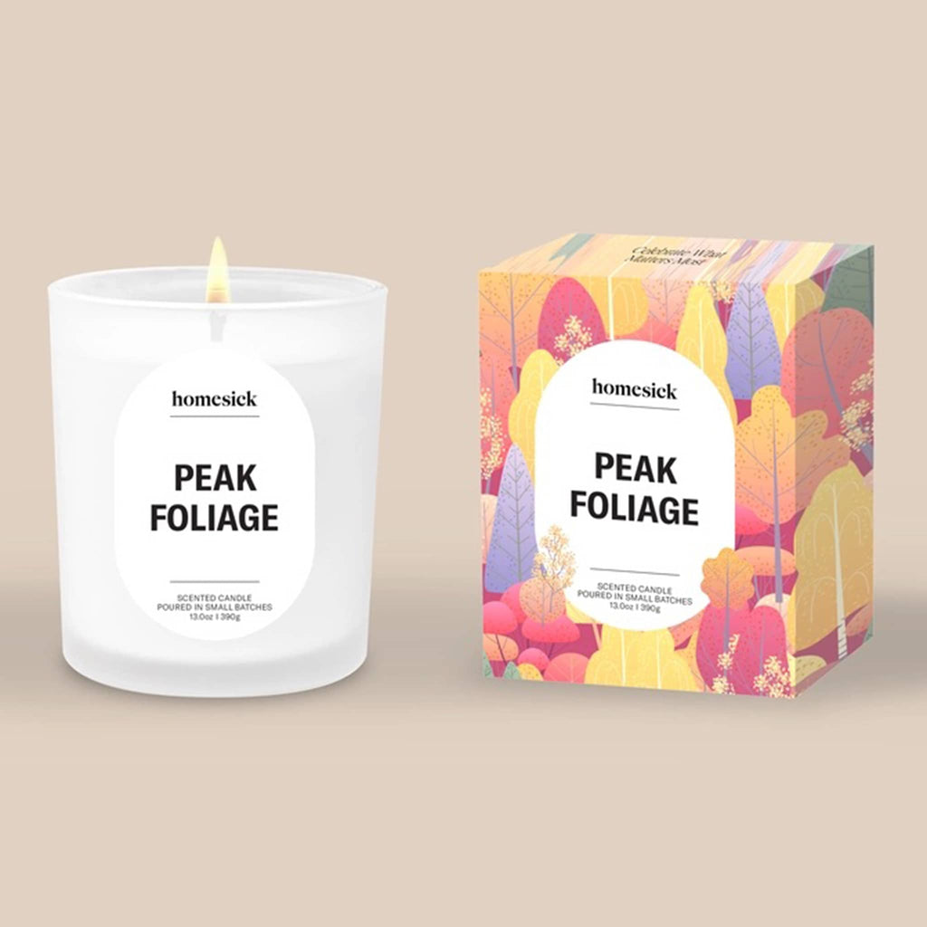 Homesick 'Peak Foliage' candle and packaging on a beige background.