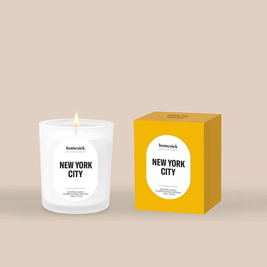 Homesick New York City mini scented candle and yellow box packaging on a beige background.