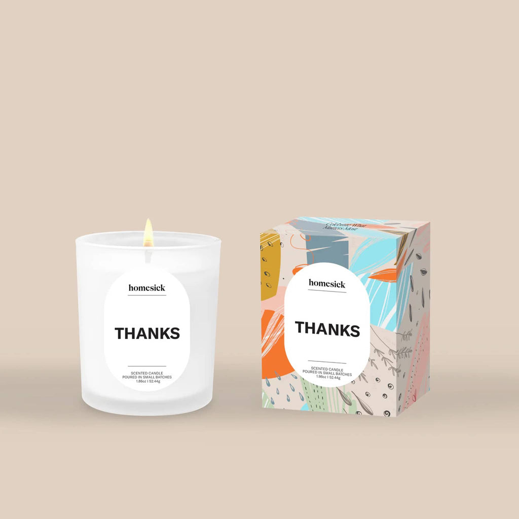 Homesick 'Thanks' mini candle and colorful box packaging on a beige background.