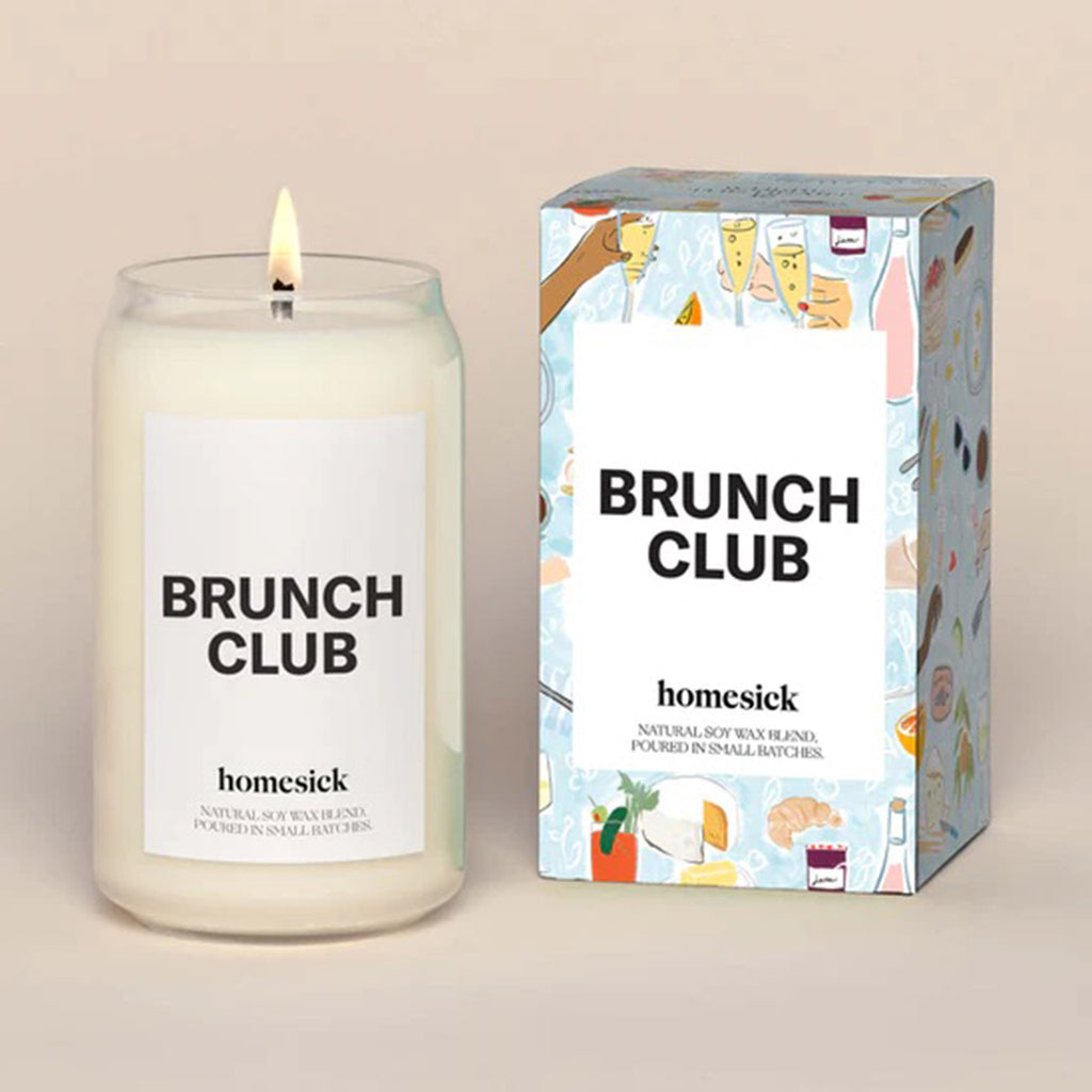 Homesick Brunch Club scented candle in a can-shaped glass vessel beside pale blue gift box with champagne toasts, bloody mary and other brunch item illustrations.