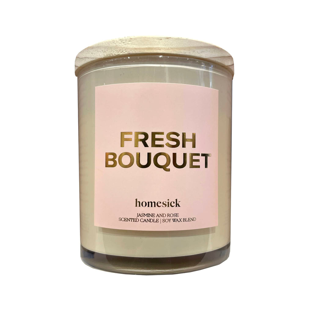 Homesick Fresh Bouquet Starter Collection jasmine and rose scented candle in a clear glass tumbler with wood lid and a pink label with "fresh bouquet" in gold foil lettering along with the logo.