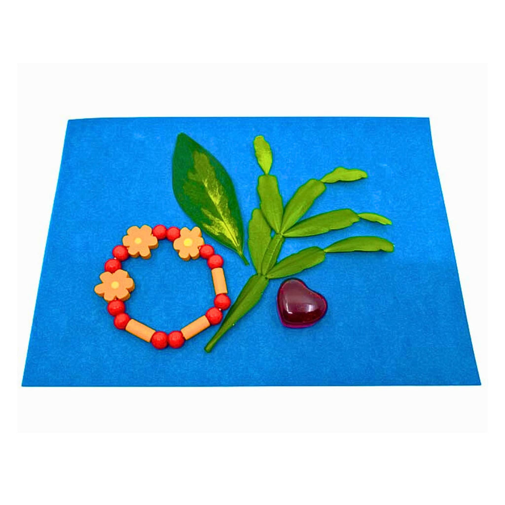 House of Marbles Sunshine Print Paper Kit, a bracelet, leaves and a heart sitting on a sheet of sun paper.