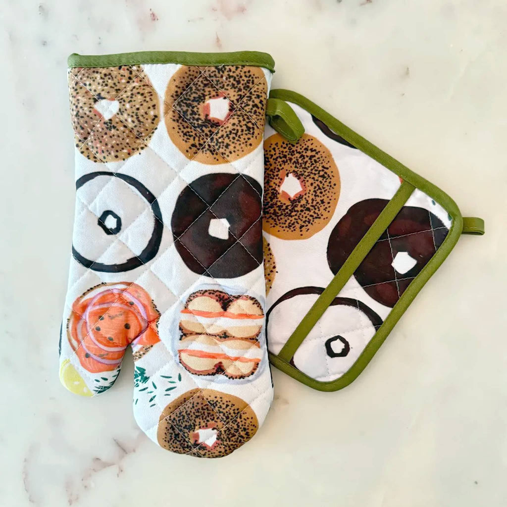 Oven mitt and pot holder with bagel design on a marble surface.