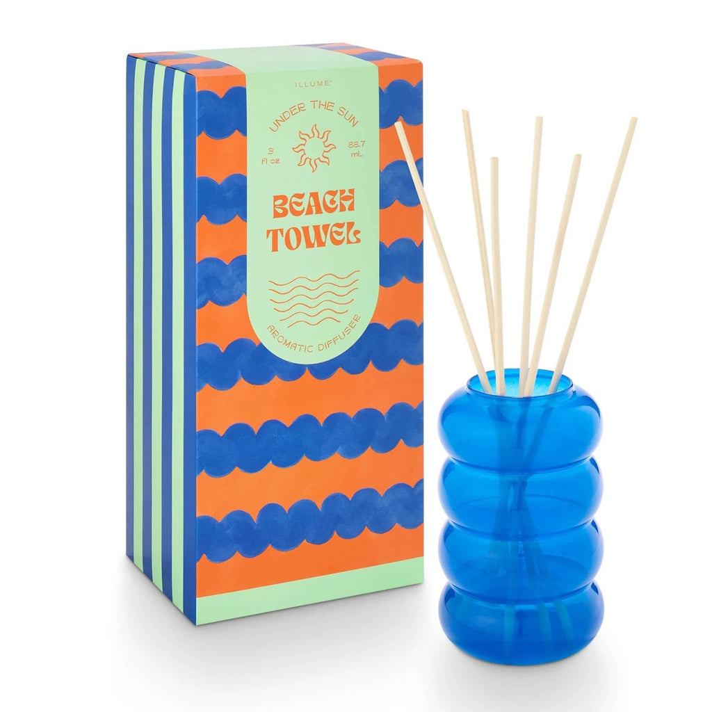 Illume Beach Towel scented aromatic sun diffuser in blue bubble glass vessel with patterned box.