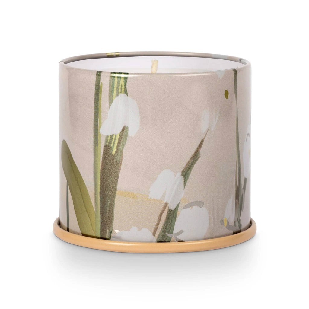Illume Isla Lily scented plant based wax candle in large vanity tin, front view with lid off.