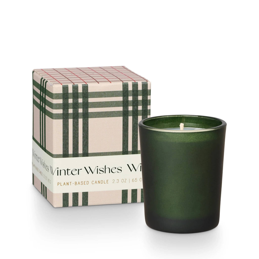 Illume Balsam & Cedar holiday scented votive candle in matte green glass vessel with green and ivory plaid gift box with "winter wishes" on the label.