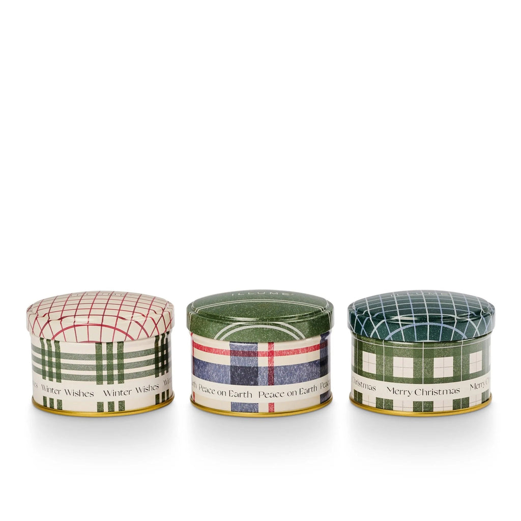 Illume Balsam and Cedar Scented Holiday Candle Mini Tin Trio Gift Set, each tin with lid has a different plaid pattern in green, red and blue.