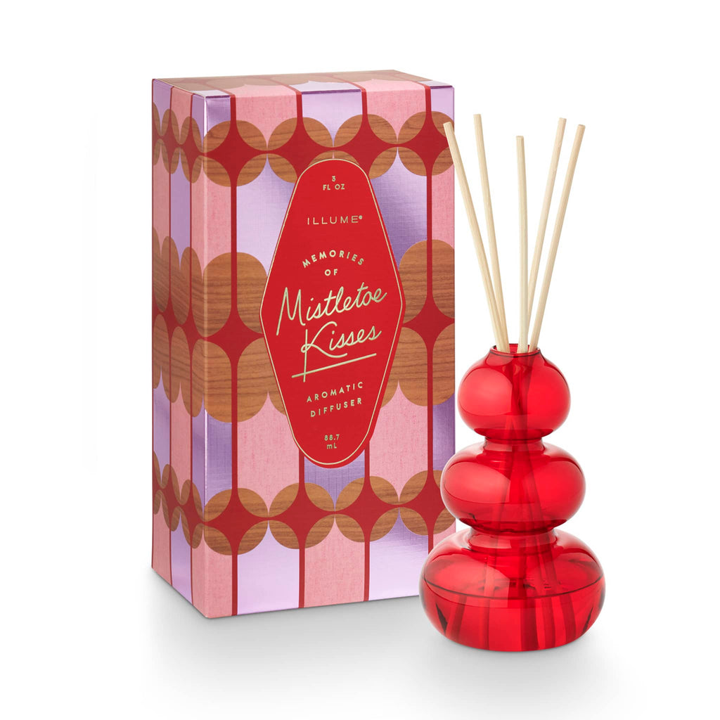 Illume Memory Lane Mistletoe Kisses scented holiday diffuser in red bubble glass vessel with natural reeds and patterned gift box.