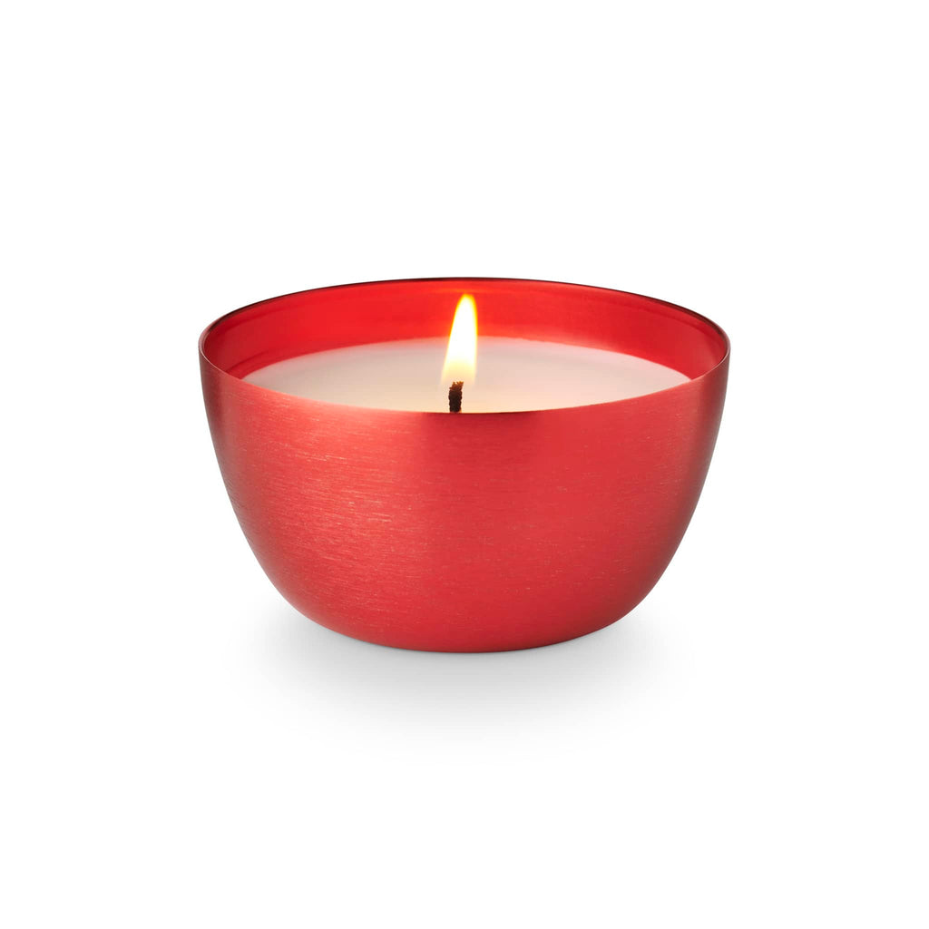 Illume Memory Lane Mistletoe Kisses holiday scented soy wax candle in red metal vessel with wick lit.