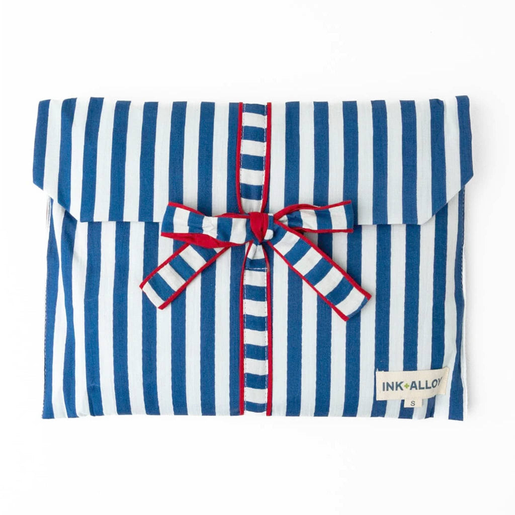 Blue and white striped pajama set in matching fabric envelope packaging with a bow, on a white background.