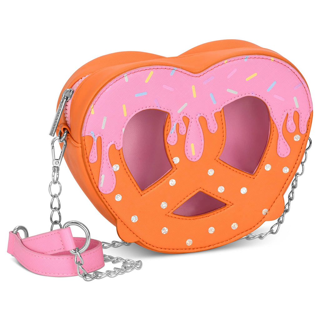 Pretzel-shaped bag with dark orange body, iridescent foil salt, pink frosting with sprinkles at the top and detachable chain link strap, front angle on a white background.