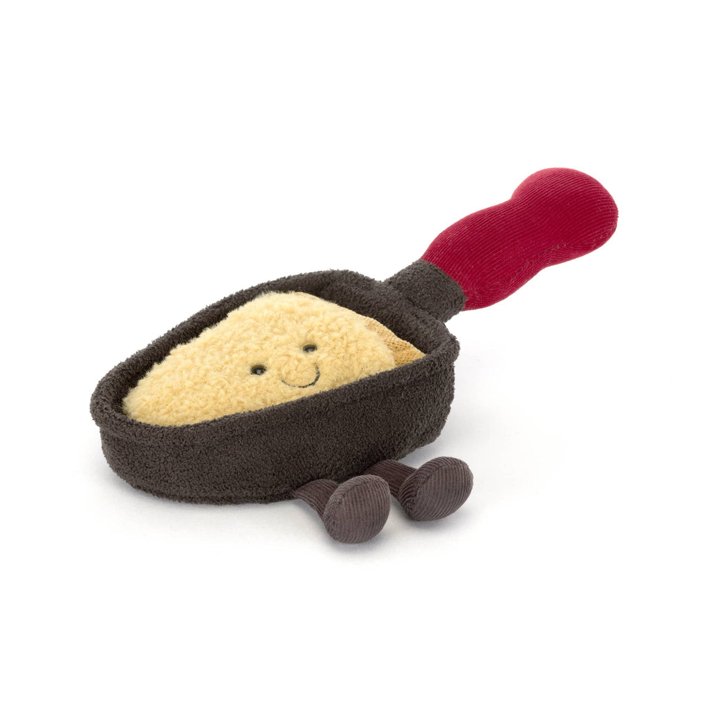 Plush brown raclette pan with smiling cheese inside and a red handle, front angle view on a white background.