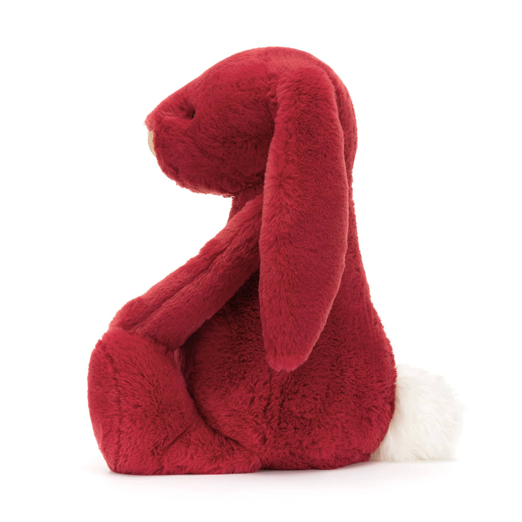 Large red plush bunny toy with floppy ears, side view, on a white background.