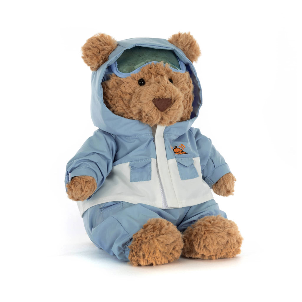 Plush teddy bear wearing a blue and white snowsuit, front angle view on a white background.