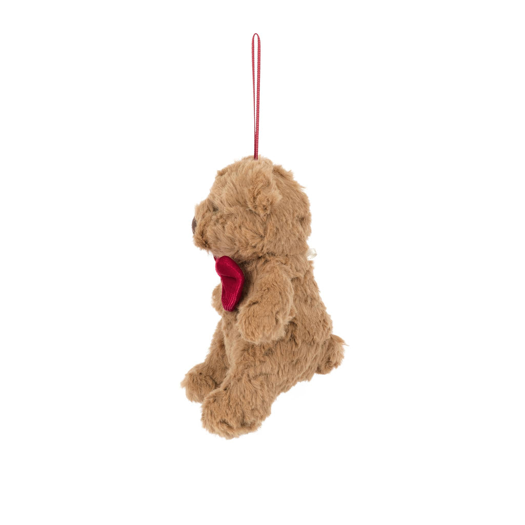Plush teddy bear ornament with a red bow tie, side view, on a white background.