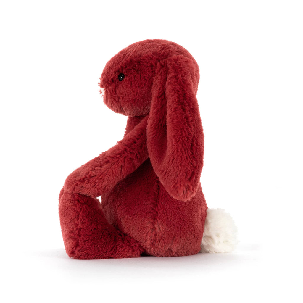 Red plush bunny toy, side view, on a white background.