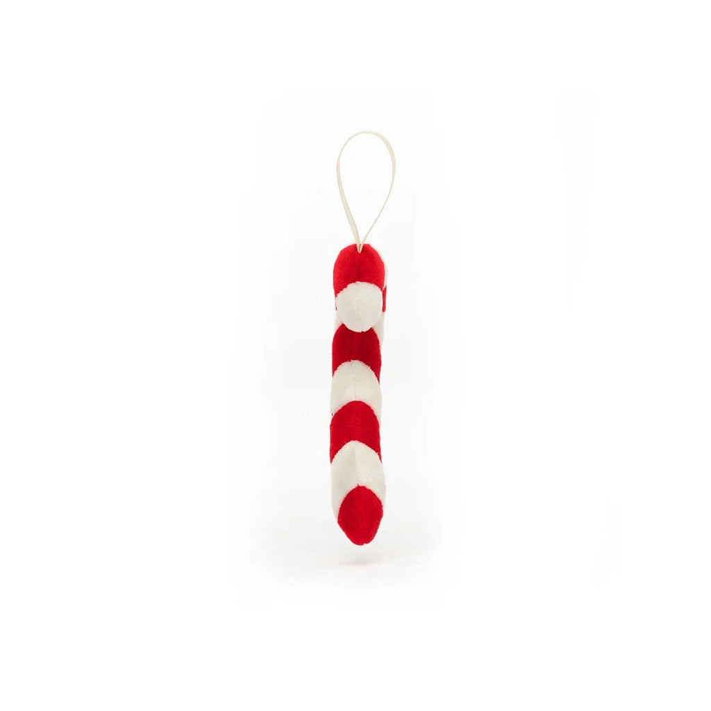 Jellycat Festive Folly Candy Cane Holiday Plush ornament, red and white striped cane shape with suede texture, black stitched eyes and mouth, white grosgrain ribbon for hanging, side view.