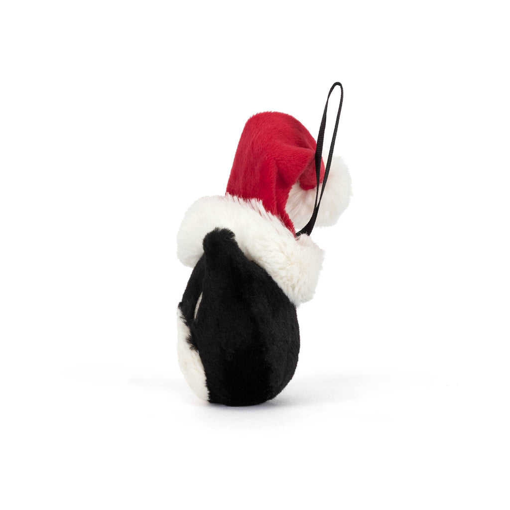 Plush black and white cat ornament with a santa hat, side view, on a white background.