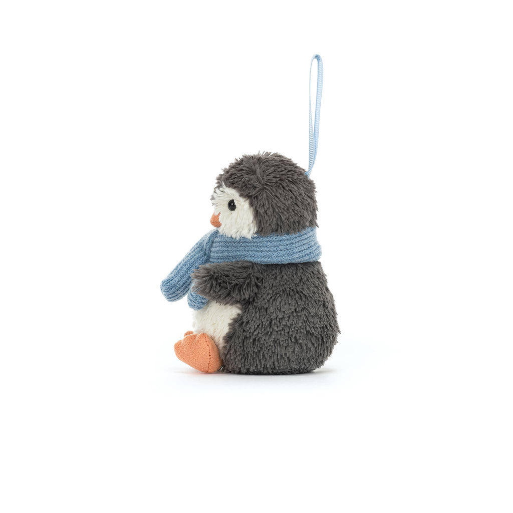 Plush penguin ornament with a blue scarf, side view, on a white background.