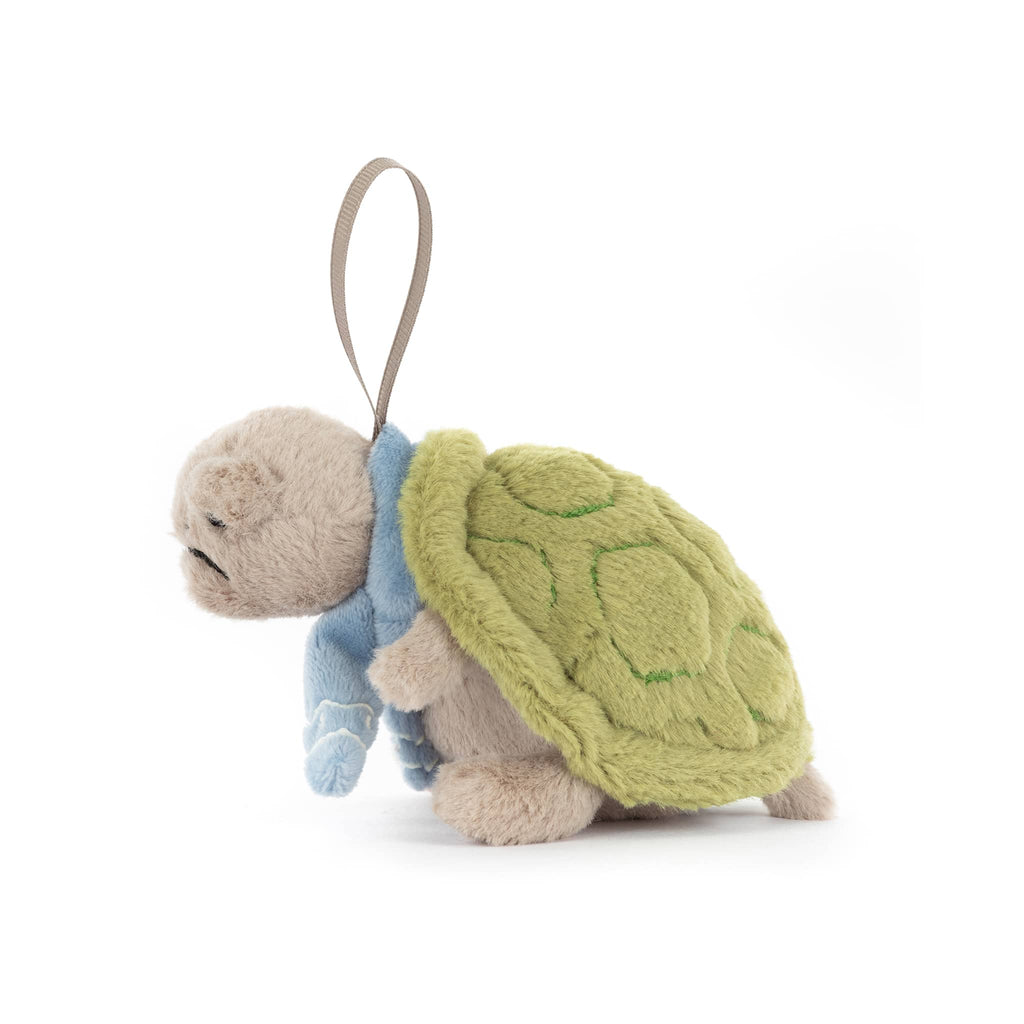 Plush turtle ornament with a blue scarf, side view, on a white background.