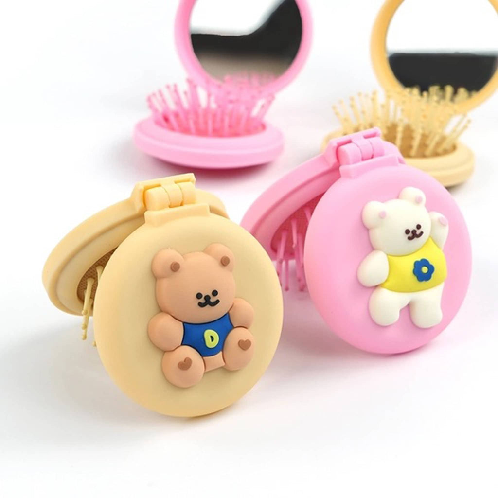 Two small round compacts in brown and pink with bear designs, two open showing built-in mirror and brush on a white background.