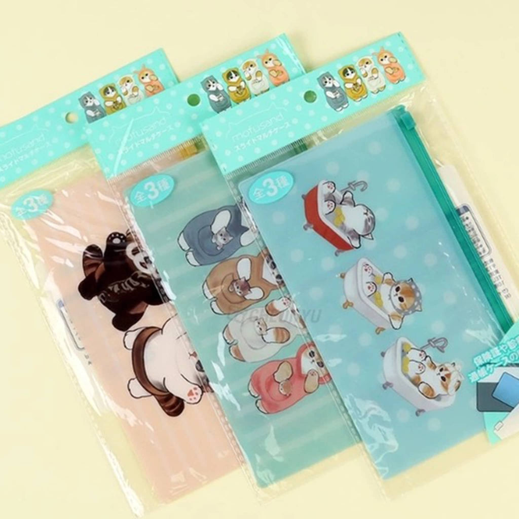 K-Wonderland Mofusand cartoon cat illustrations on milky pencil pouches in pink, green and blue, in packaging on a yellow background.