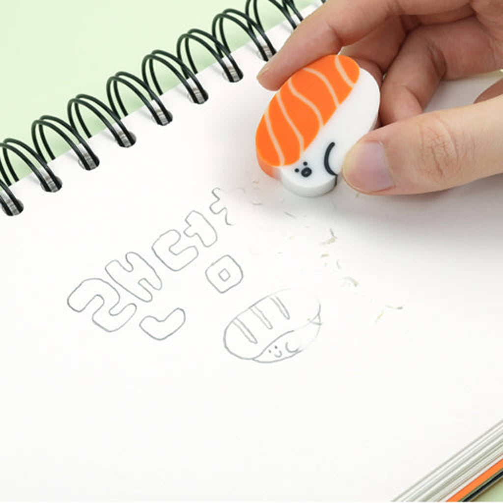 Sushi-shaped eraser being used on a notebook with cartoonish drawings.