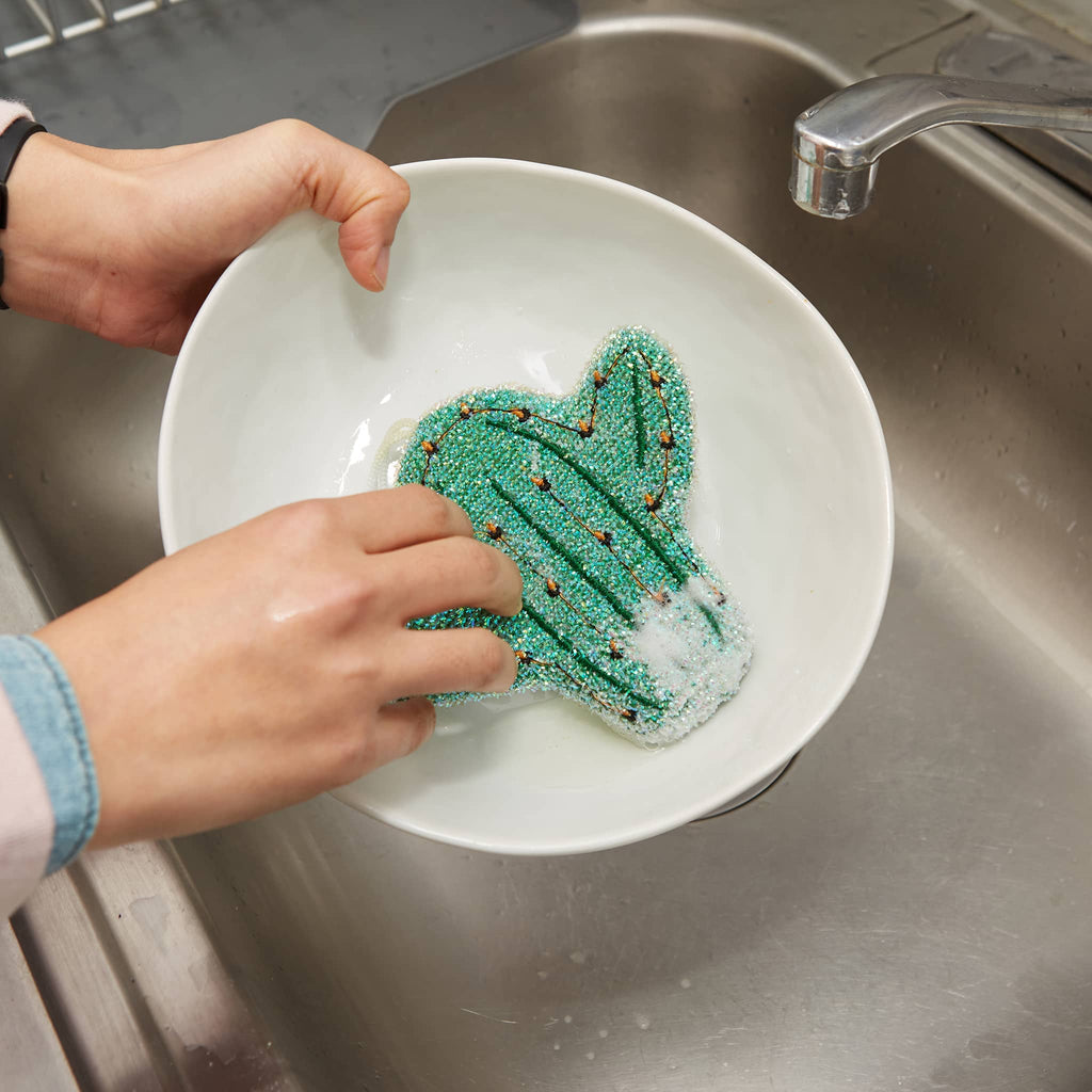 Kikkerland Cactus Scrub Sponge, in use washing a bowl in a sink.