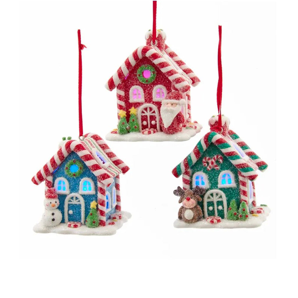 Kurt Adler Gingerbread Candy House battery-operated LED holiday tree ornament in blue with snowman, red with santa or green with reindeer, all with glittery sugared effect.
