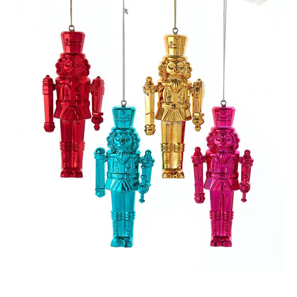Four colorful shiny nutcracker ornaments hanging against a white background.
