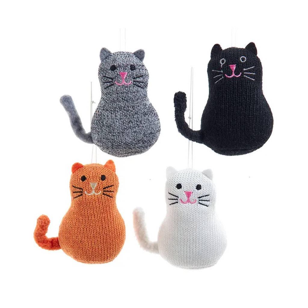 Four knitted cat ornaments in different colors hanging against a white background.