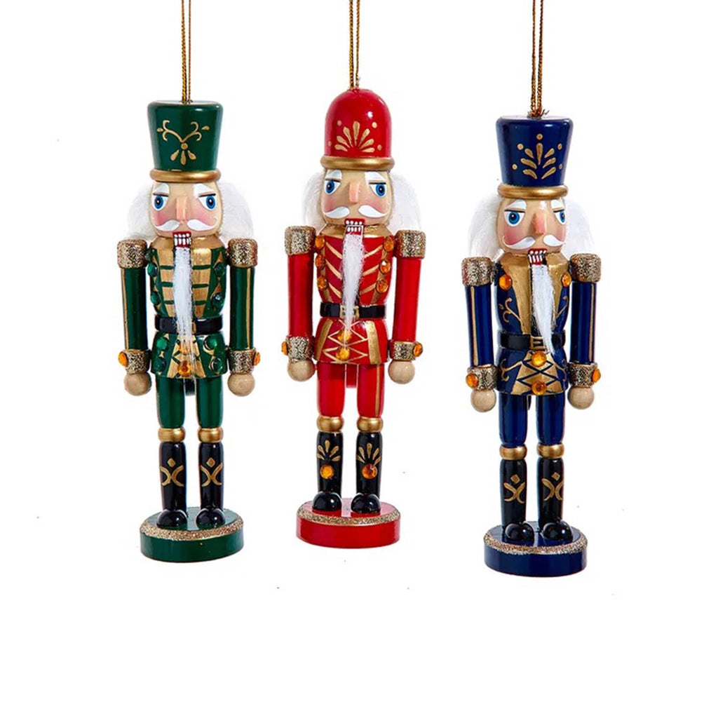Three colorful nutcracker ornaments on a white background.