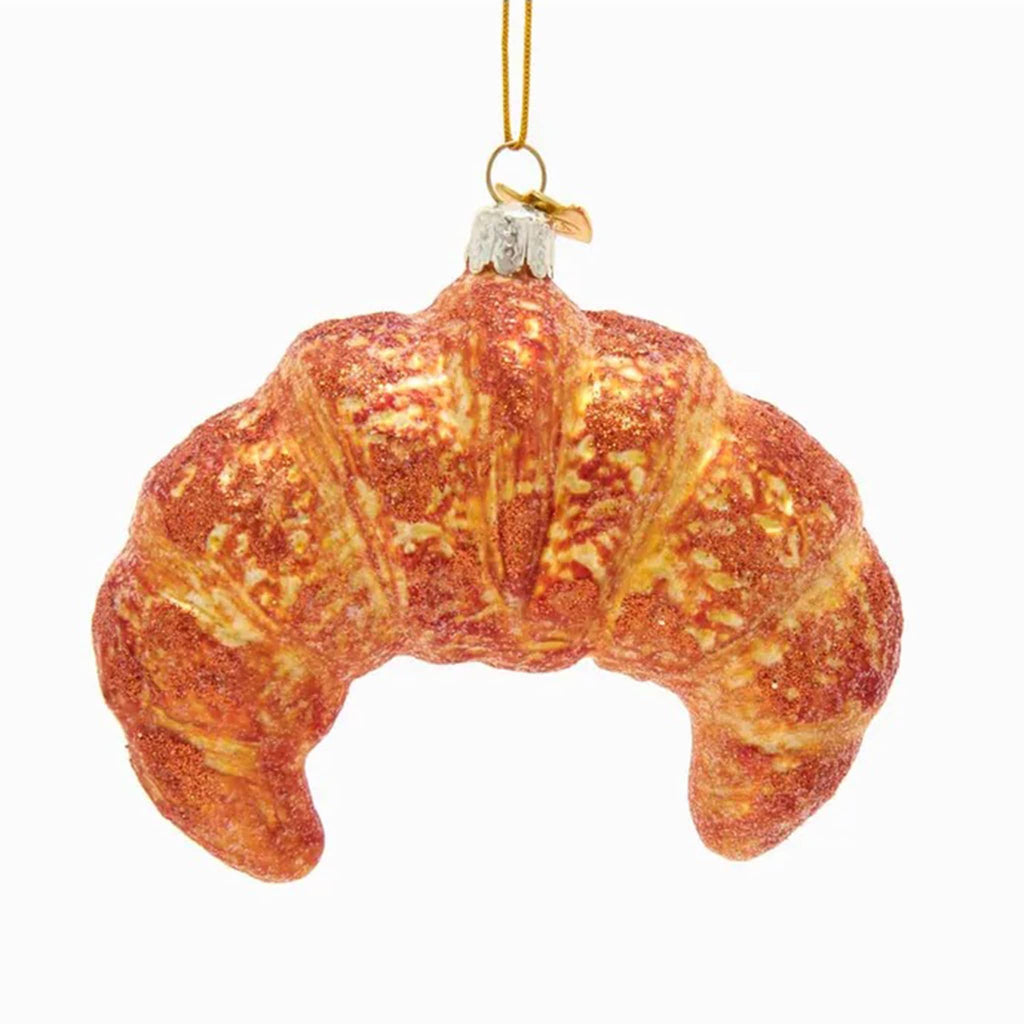 Croissant-shaped glass ornament on a white background.