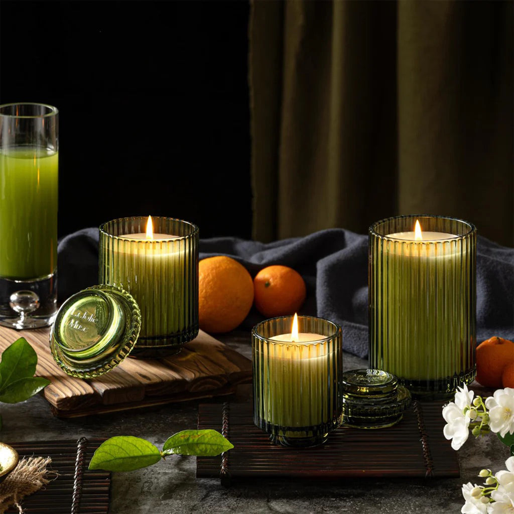 La Jolie Muse Amelie Mandarin Matcha scented soy wax candle in ribbed green glass vessels with lids, in 3 sizes, in table setting.