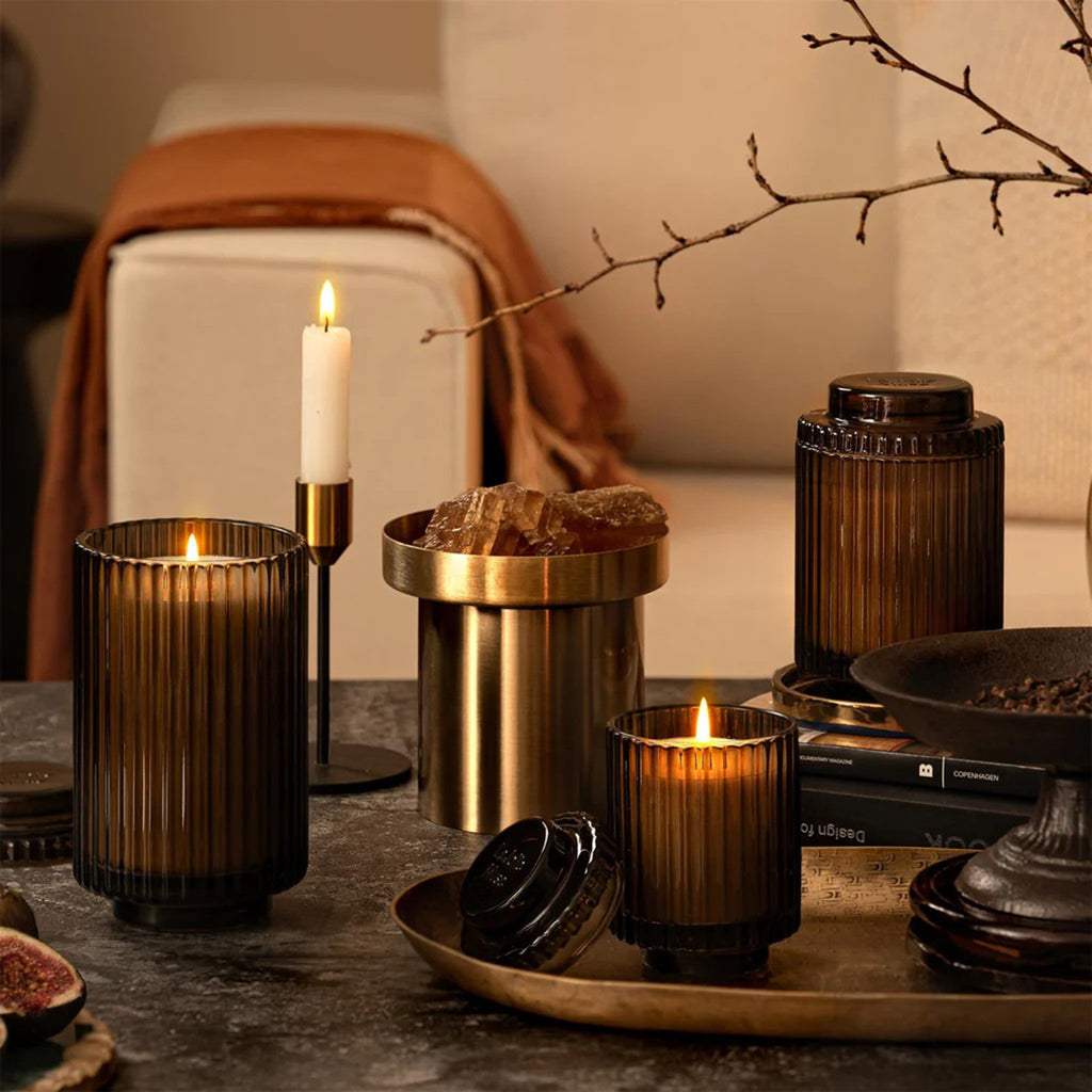 La Jolie Muse Amelie Santal Himalayen scented soy wax candles in ribbed brown glass vessels with lids, in 3 sizes, in table setting..