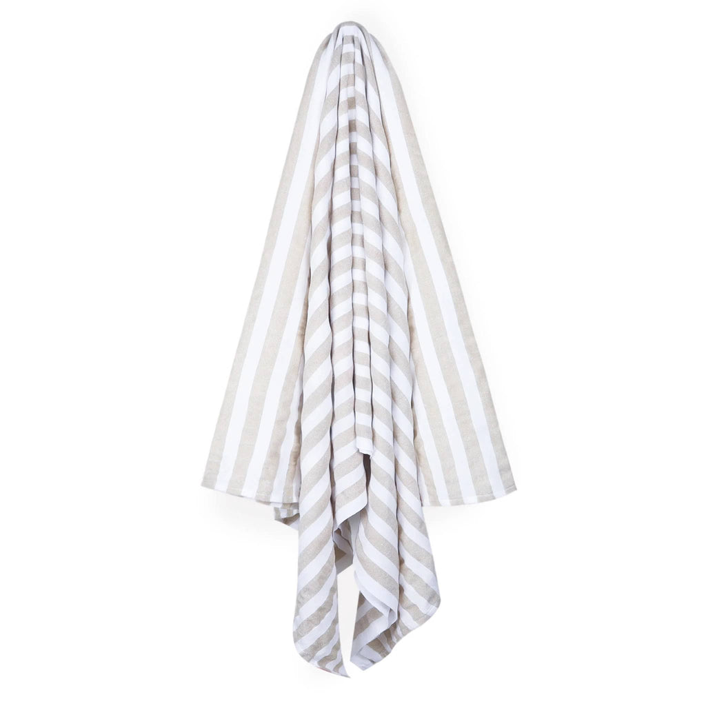 Las Bayadas La Catalina beach blanket towel with beige and white stripes, hanging.