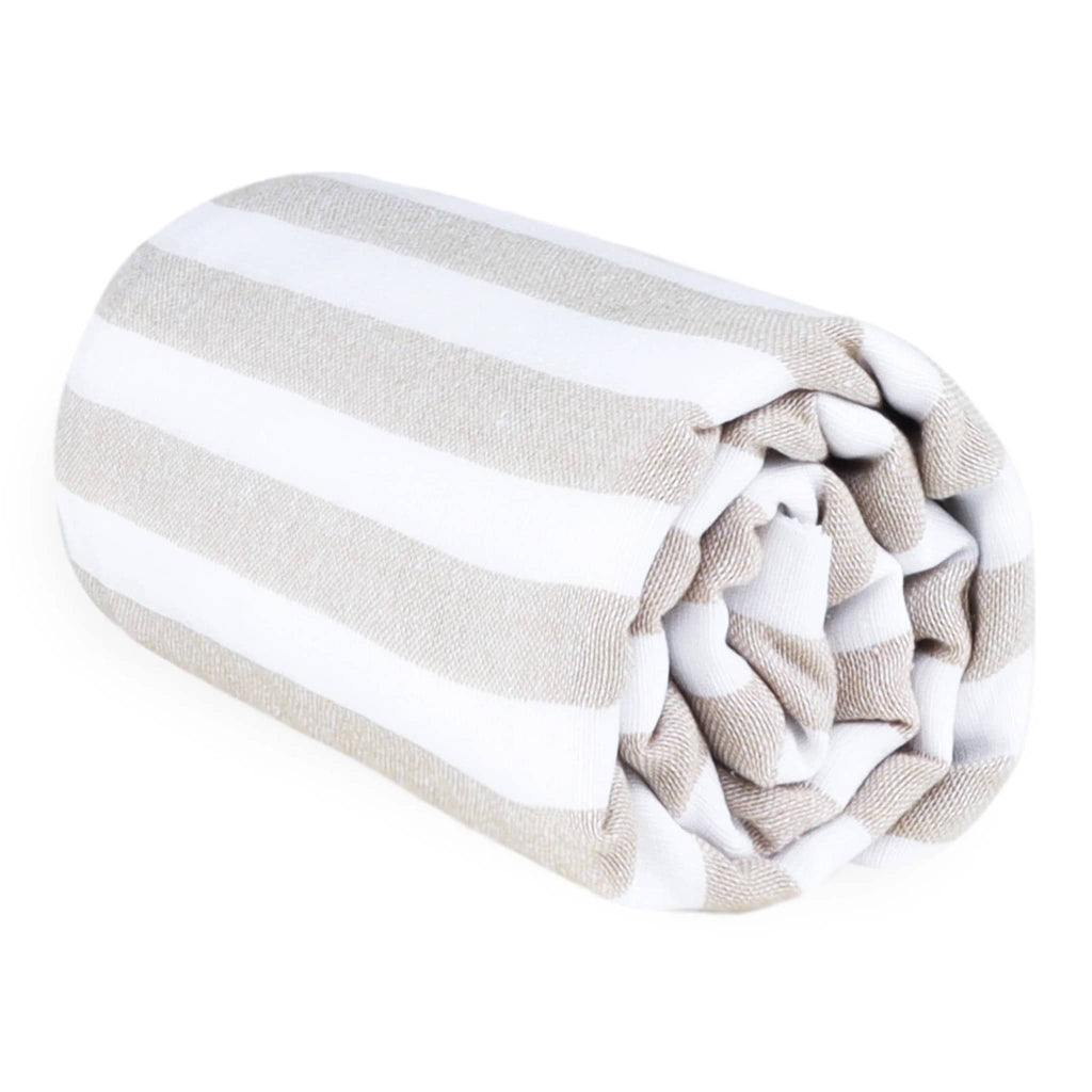 Las Bayadas La Catalina beach blanket towel with beige and white stripes, rolled up.