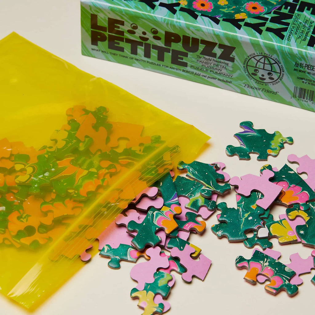 Le Puzz 81 piece Flower Friend mini jigsaw puzzle with box packaging and pieces coming out of a yellow reusable bag.