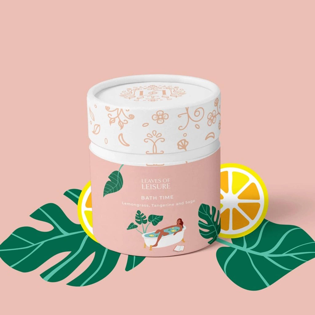 Leaves of Leisure Bath Time Lemongrass, Tangerine and Sage Low Caffeine Organic Tea in illustrated peach canister packaging, front view, on peach background.