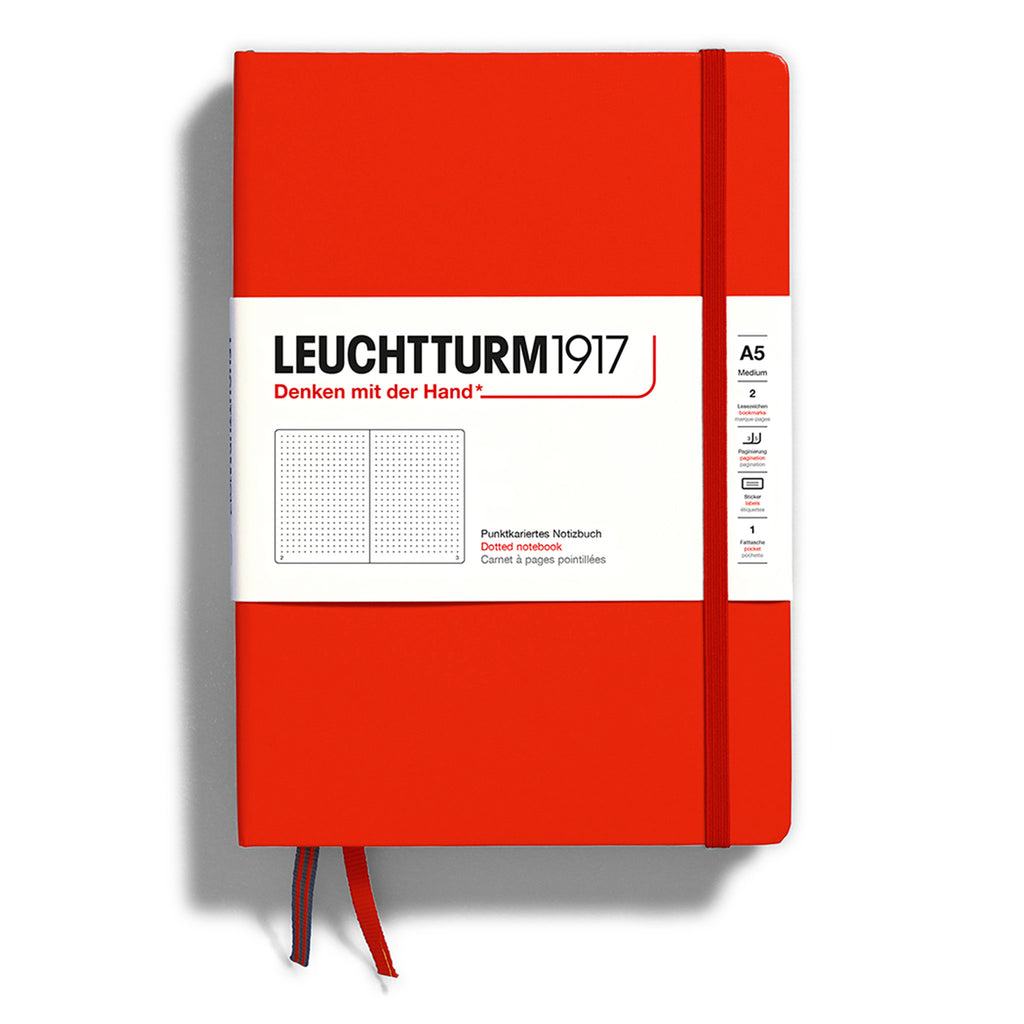 Leuchtturm1917 hardcover A5 medium notebook with dotted pages and a fox red cover and elastic band.