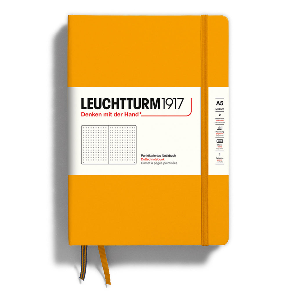 Leuchtturm1917 hardcover A5 medium notebook with dotted pages and a rising sun orange cover and elastic band.